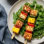 Mango-Halloumi-Spiesschen auf Rucolasalat